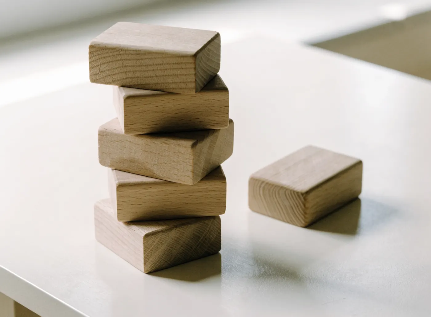 Blocs de bois empilés sur une table claire, un bloc mis à part