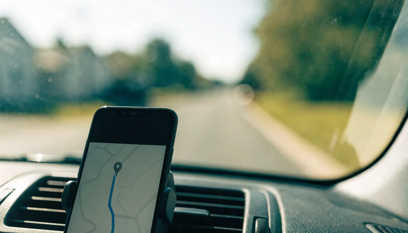 Téléphone fixé au tableau de bord d’une auto, carte affichée à l’écran